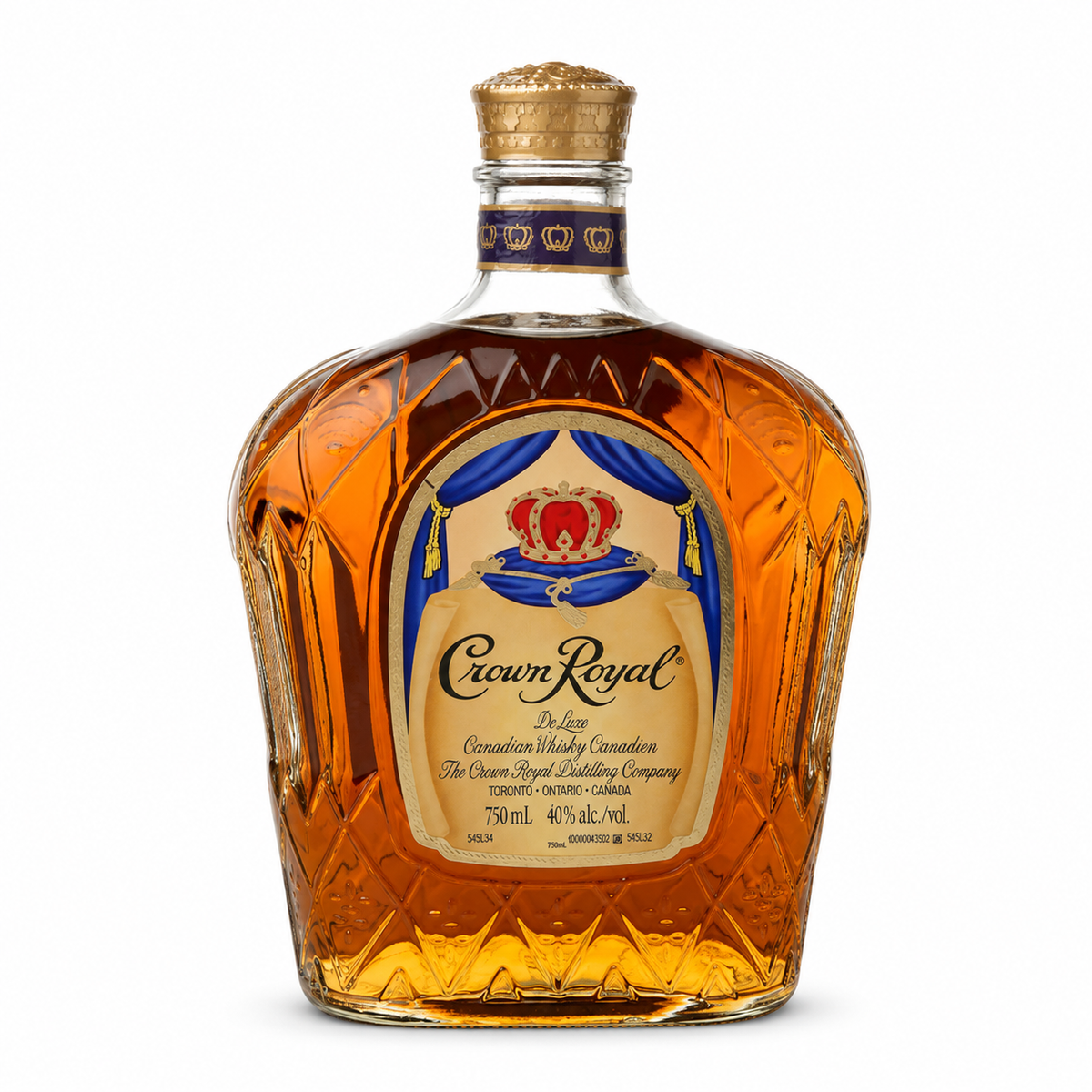 A bottle of Crown Royal De Luxe Canadian Whisky on a solid white background. The bottle is made of faceted crystal glass, filled with amber-colored whisky, and features a gold crown cap and a detailed cream, blue, and red label.